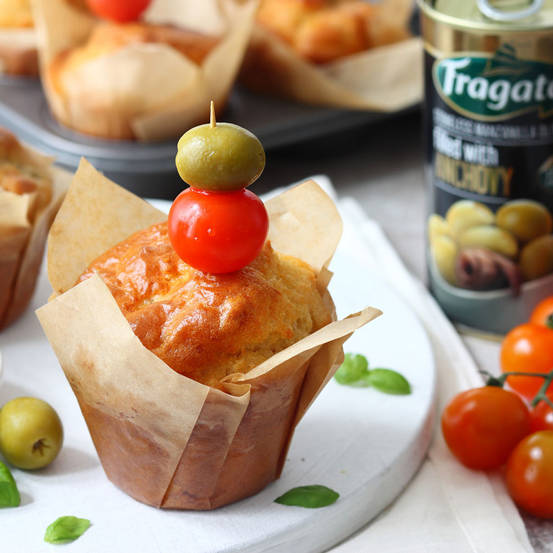 Savoury muffins with cherry tomatoes and mozzarella. With a side dish of olives.